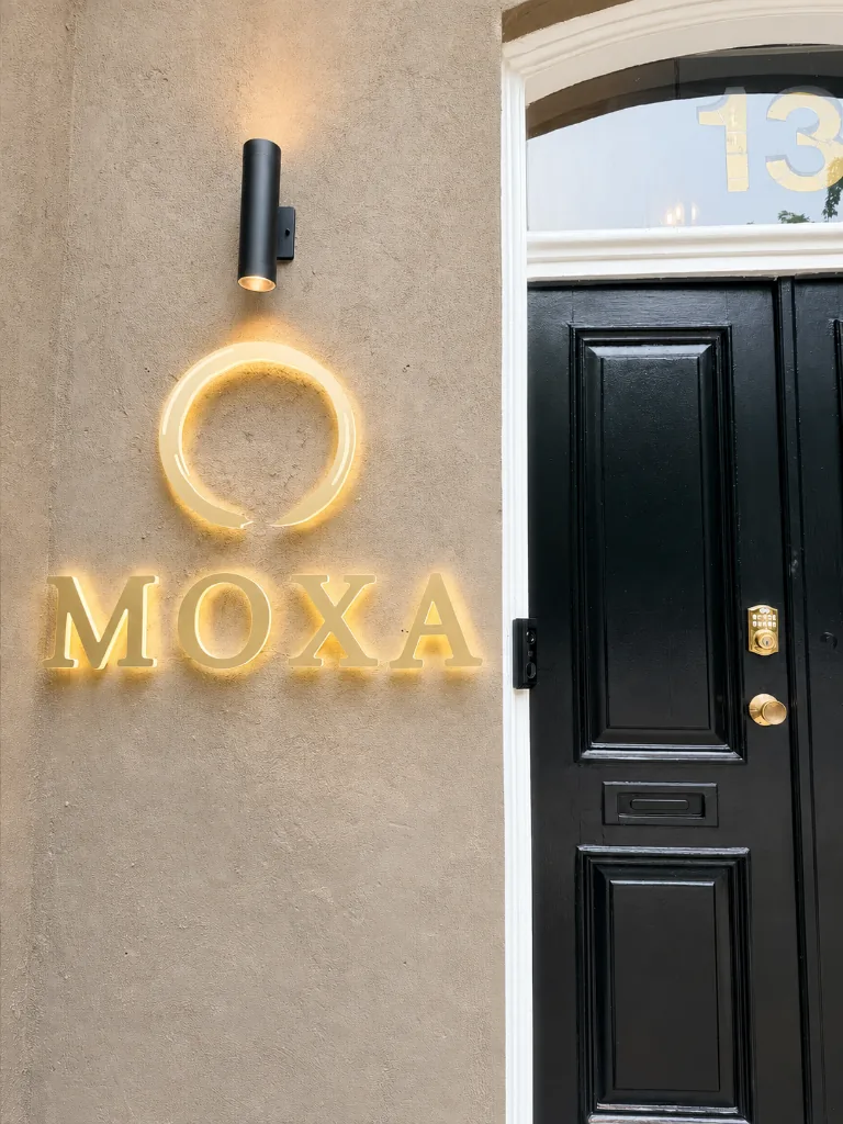 MOXA illuminated entrance sign and black front door at 13 Clarence Square Toronto